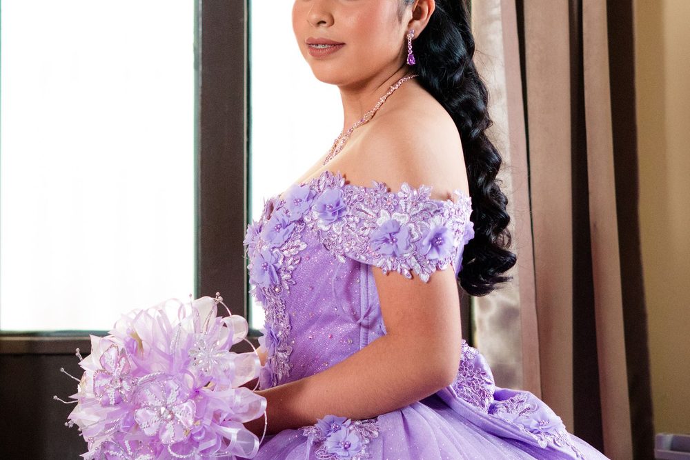 Quinceañera con vestido lila y ramo
